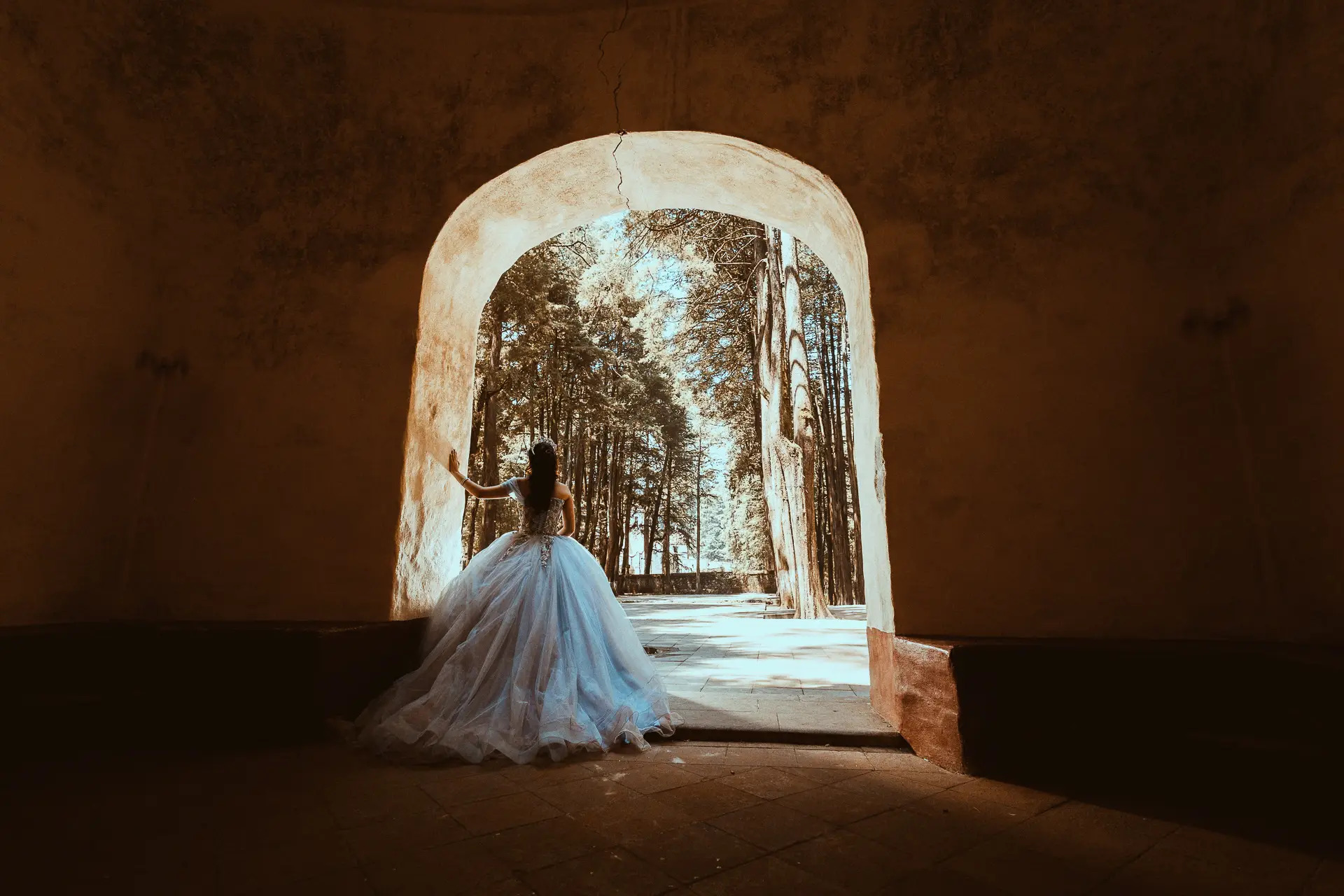 Quinceañera con vestido azul en arco colonial con vista al bosque mexicano, sesión XV años editorial Salicatus