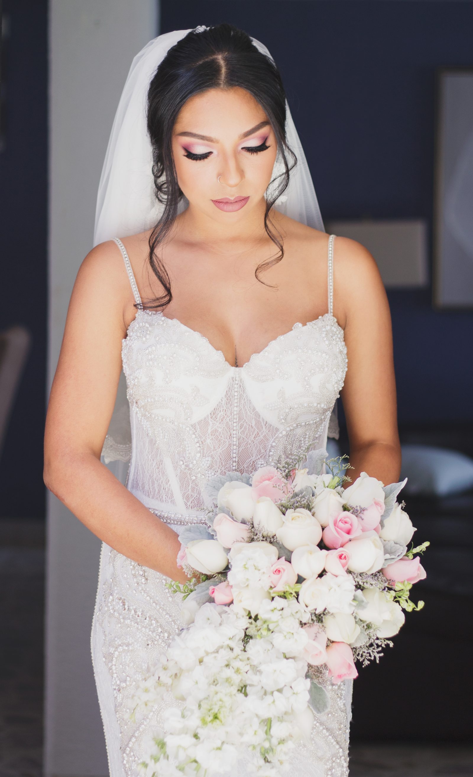 Novia con vestido de encaje sosteniendo ramo de rosas blancas y rosadas — preparativos
